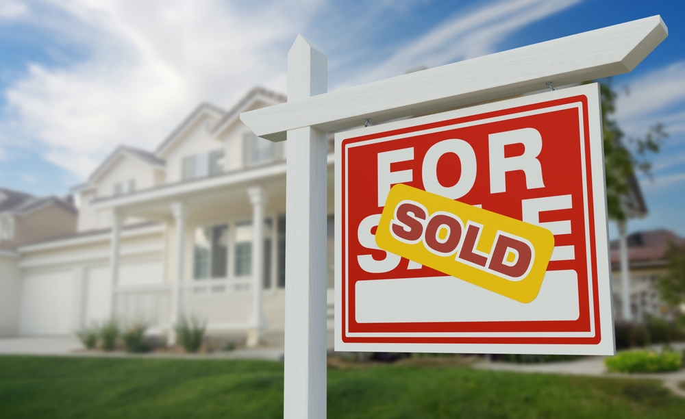 house sold sign in front of house